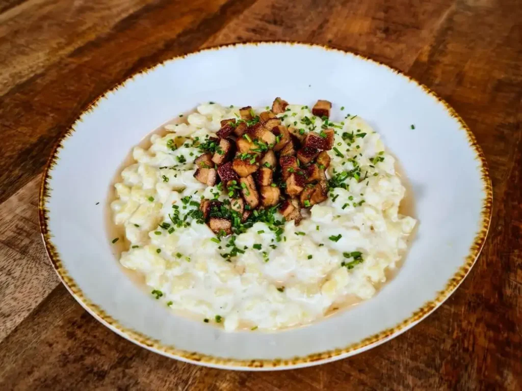 Authentic homemade Slovak bryndza dumplings served with bacon and chives